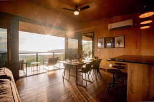uma sala de estar com uma mesa e cadeiras e uma grande janela em Casa Pelícano - Tropical house w' private pool and ocean views em Playa Venao