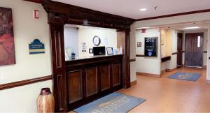 a lobby with a bar in the middle of a building at Baymont by Wyndham Battle Creek/I-94 in Battle Creek