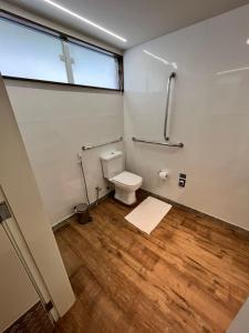 a bathroom with a toilet and a cross on the wall at Capri Hotel in Duque de Caxias