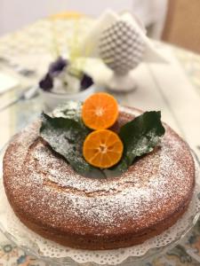 タオルミーナにあるB&B Giuliaのグラス皿の上にケーキとオレンジ