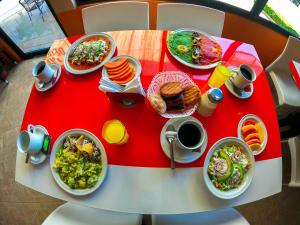 una mesa roja y blanca con platos de comida. en Hotel Villa De Las Flores en Zacatlán