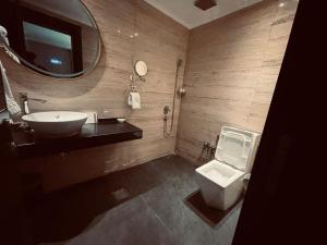 a bathroom with a sink and a toilet and a mirror at The Capital Heart Hotel in Baghdad