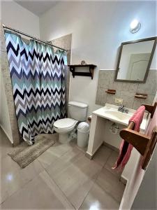 W łazience znajduje się toaleta, umywalka i lustro. w obiekcie Casa Loma Bella 1 con Alberca Privada Vista Increible w mieście San Carlos