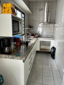 uma cozinha com um lavatório e um micro-ondas em Hostel do Mineiro em São José dos Campos
