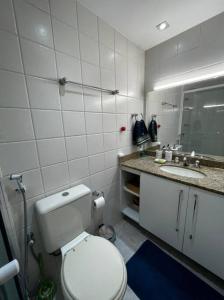 uma casa de banho branca com um WC e um lavatório em Barra Praia Bourbon no Rio de Janeiro