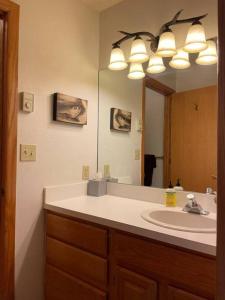 a bathroom with a sink and a large mirror at 100 Steps Away Ski in Ski Out Condo in Big Sky