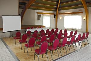 a conference room with red chairs and a white board at La Route d'Argent in Bozouls