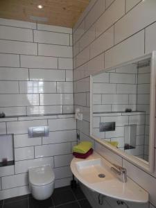 y baño con lavabo, espejo y aseo. en Kleiner Bungalow mit einem Schlafzimmer, en Puerto Naos
