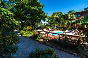Un patio trasero con piscina, sillas y árboles. en Cocolobo Resort, en West End