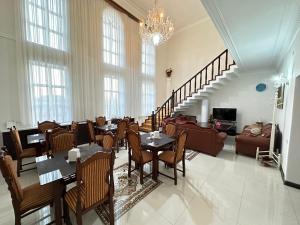 a dining room with tables and chairs and a chandelier at Sarbon Hotel Tashkent in Tashkent
