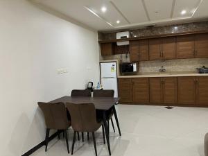 a kitchen with a table and chairs and a refrigerator at ليالي الين للشقق المخدومة in Buraydah