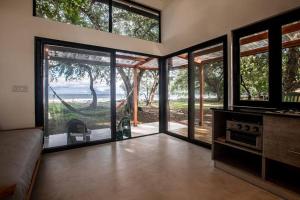 a living room with sliding glass doors with a hammock at Body - Tiny Home Venao Cove in Playa Venao