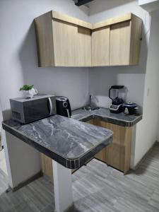 cocina con encimera y microondas en Departamento Cali moderno, en Cali