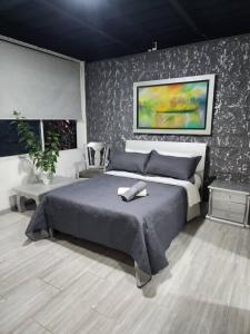 1 dormitorio con 1 cama y una pintura en la pared en Departamento Cali moderno, en Cali