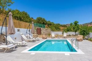 a pool with chaise lounge chairs and a swimming pool at Villa Koupos in Karé