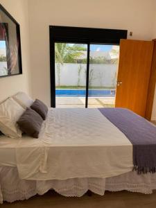 sypialnia z dużym łóżkiem i dużym oknem w obiekcie Casa de Campo Ninho Verde 2 w mieście Pardinho
