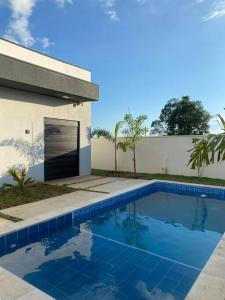 una piscina di fronte a un edificio con garage di Casa de Campo Ninho Verde 2 a Pardinho