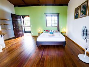 um quarto com uma cama num quarto com paredes verdes em El Caribeo em Bocas Town