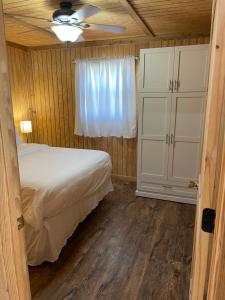 1 dormitorio con 1 cama y ventilador de techo en Bixby Cove Cabin #1 en Porum