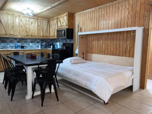 1 dormitorio con cama, mesa y cocina en Bixby Cove Cabin #1 en Porum