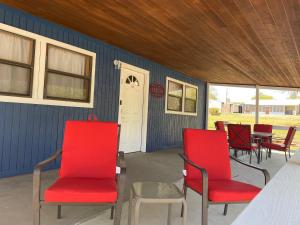 a group of red chairs sitting on a patio at Bixby Cove Cabin #1 in Porum