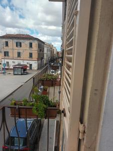 un balcón con macetas en el lateral de un edificio en B&B Le Finestre Su Via Cavour, en Sassari