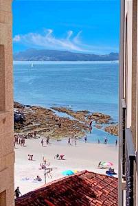 grupa ludzi na plaży blisko oceanu w obiekcie 1ª línea paseo-playa de Silgar, portal a 20 pasos w mieście Sanxenxo