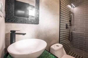 bagno con vasca, servizi igienici e TV di Mind- Tiny Home Venao Cove a Playa Venao Altre 17 foto