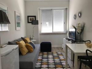 una pequeña sala de estar con sofá y escritorio en Cosy 2 Bedrooms Apartment in Arroios - SSL 3A en Lisboa