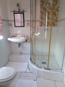 a bathroom with a shower and a toilet and a sink at Ezamampondo Guest House in King Williamʼs Town