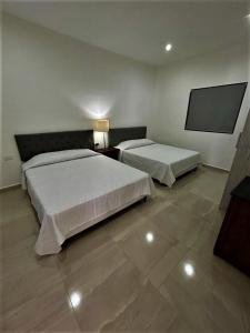 1 dormitorio con 2 camas y TV de pantalla plana en Casa Loma Bella 1 con Alberca Privada Vista Increible, en San Carlos