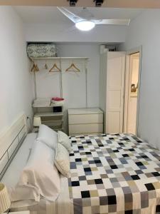 ein Schlafzimmer mit einem Bett mit einem karierten Boden in der Unterkunft Estudio Puerto Deportivo Marbella in Marbella