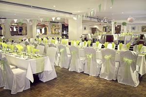 a room with white tables and chairs with yellow bows at Afton Hotel in Eastbourne
