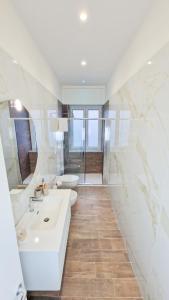 a white bathroom with a sink and a toilet at B&B Gelso Rosso Pompei in Pompei
