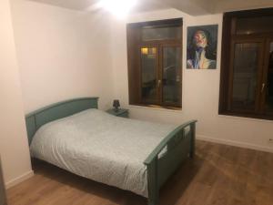 um quarto com uma cama e um quadro na parede em Logement entier sur Wormhout em Wormhout