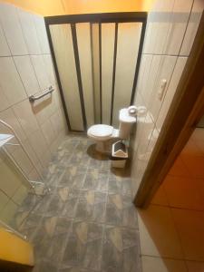 a bathroom with a toilet and a tile floor at Cabinas La Casona Del Pirata in La Cruz