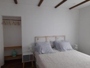 a bedroom with a white bed with pillows at Monte das Rolas - A Serenidade mora Aqui! in Ferraria +29 photos
