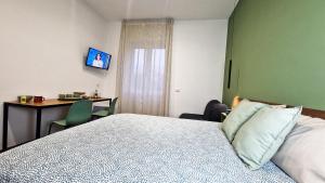 a bedroom with a bed and a desk with a computer at B&B Gelso Rosso Pompei in Pompei