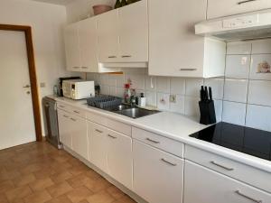 a kitchen with white cabinets and a sink at Perk25A in Steenokkerzeel