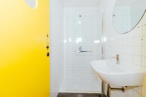 a white bathroom with a sink and a shower at Surf & Sea Suites in Parede