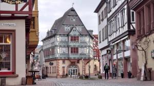 an old building with a turret on a city street at Hotel zum Riesen - älteste Fürstenherberge Deutschlands in Miltenberg +20 photos