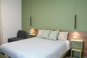 a bedroom with a bed with pillows and a chair at B&B Gelso Rosso Pompei in Pompei