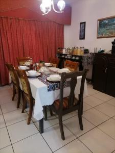 een eettafel met een wit tafelkleed en stoelen bij Ezamampondo Guest House in Koning Willemstad