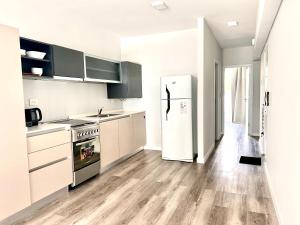 a kitchen with white appliances and a refrigerator at Depto con vista al río Paraná. in San Nicolás de los Arroyos