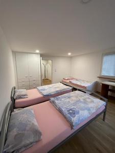 a room with four beds in a room with a window at Casa Veli Apartments in Offenburg