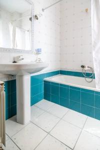 Un baño azul y blanco con lavabo y bañera. en La Veguilla Úbeda, en Úbeda