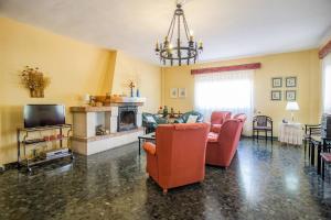 Una sala de estar con sillas rojas y una chimenea. en La Veguilla Úbeda, en Úbeda