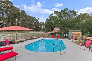 una piscina con sedie rosse e un tavolo da picnic di Stonegate Lodge - Pool & Firepits Room #208 a Eureka Springs