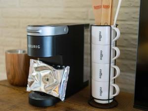 una macchinetta del caffè seduta su un tavolo accanto a una scatola di Stonegate Lodge - Pool & Firepits Room #208 a Eureka Springs