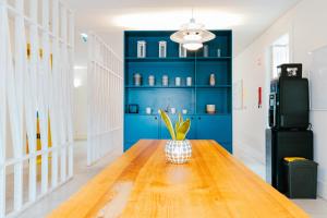 a dining room with blue walls and a wooden table at Surf & Sea Suites in Parede